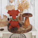 tommy the fox sitting next to a wooden mushroom and a wooden squirrel