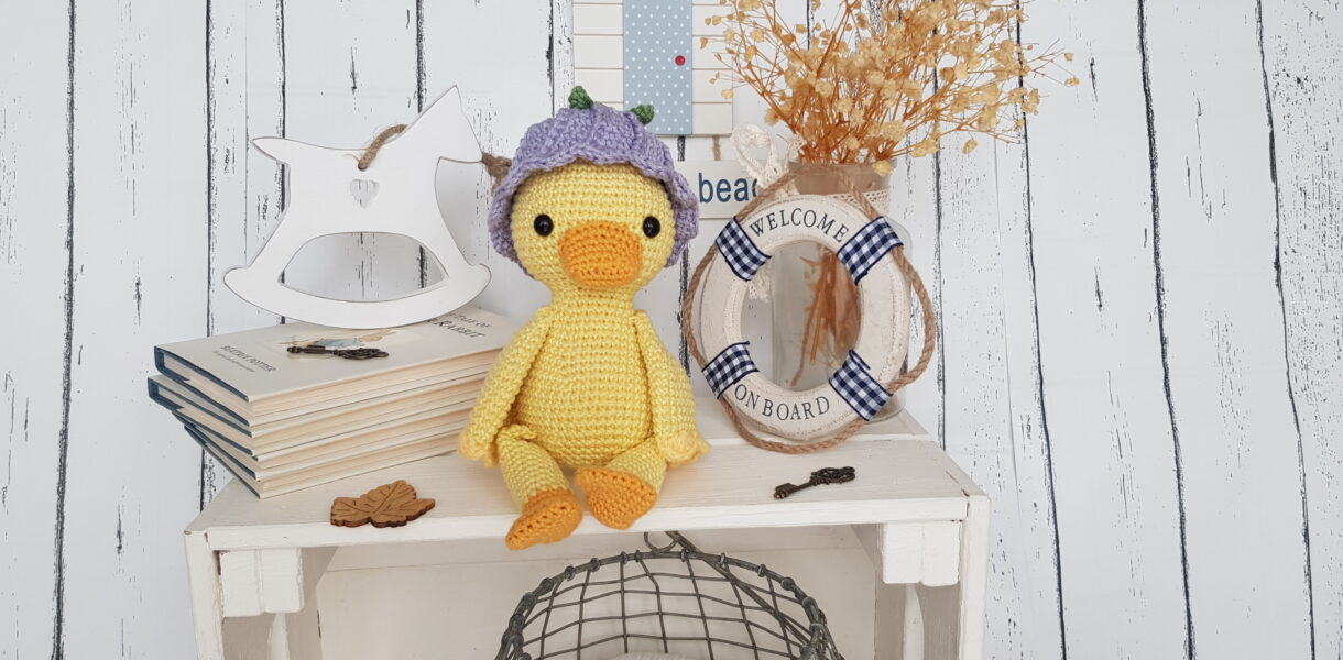 crochet duck sitting next to a swimming ring