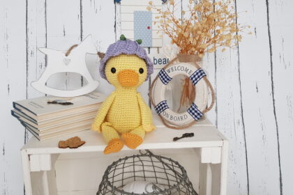 crochet duck sitting next to a swimming ring