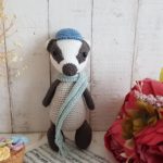 crochet badger standing with a scarf around his neck