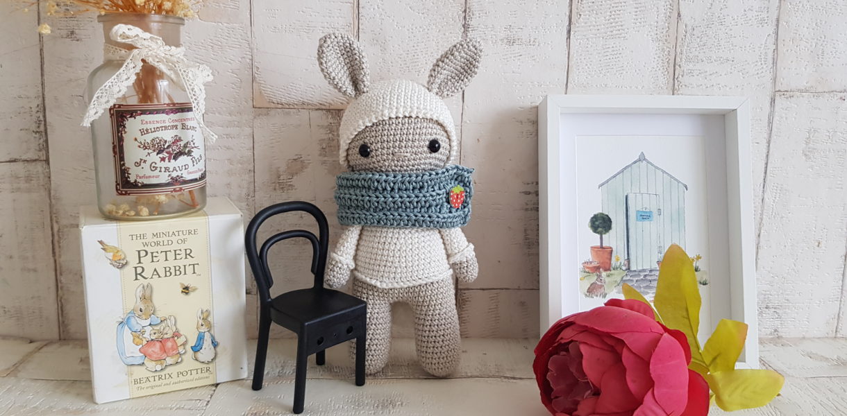 crochet bunny standing next to a bunny picture