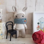 crochet bunny standing next to a bunny picture