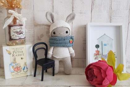 crochet bunny standing next to a bunny picture