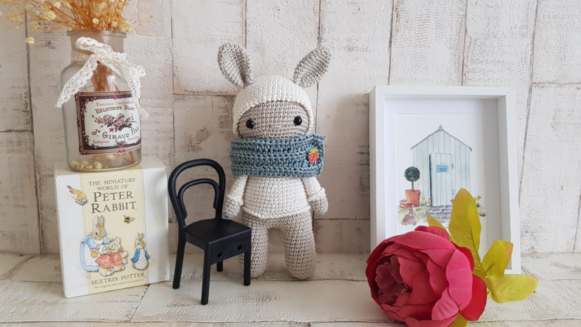 crochet bunny standing next to a bunny picture