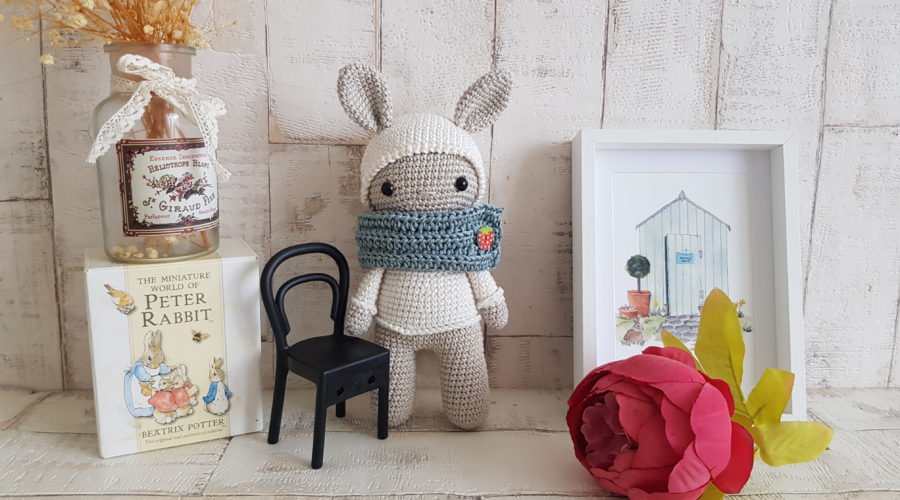 crochet bunny standing next to a bunny picture