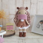 crochet doll standing next to a piano, a rocking horse and a nice painting