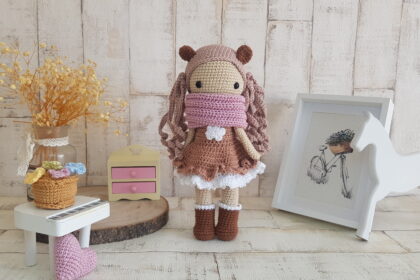 crochet doll standing next to a piano, a rocking horse and a nice painting