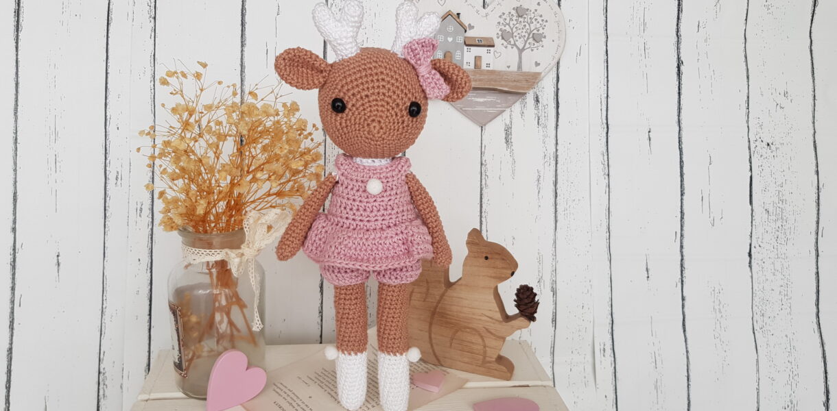 crochet deer standing next to a wooden squirrel