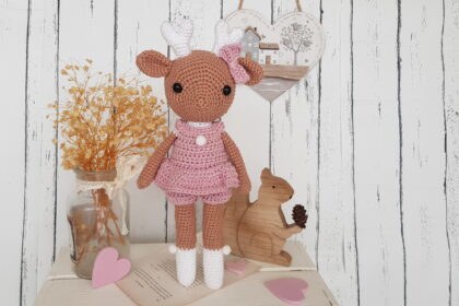 crochet deer standing next to a wooden squirrel